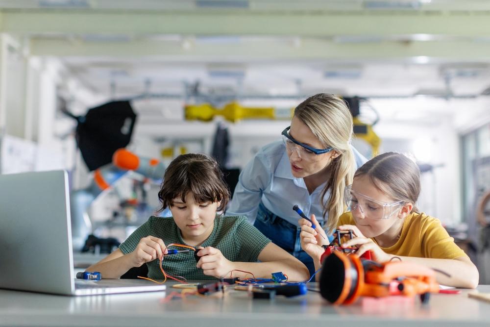 Niñas realizando un ejercicio de ciencias para descubrir el funcionamiento de un mecanismo electrónico