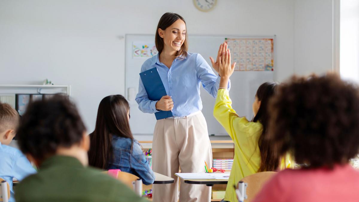 Profesora motivando a su alumnado chocando las manos