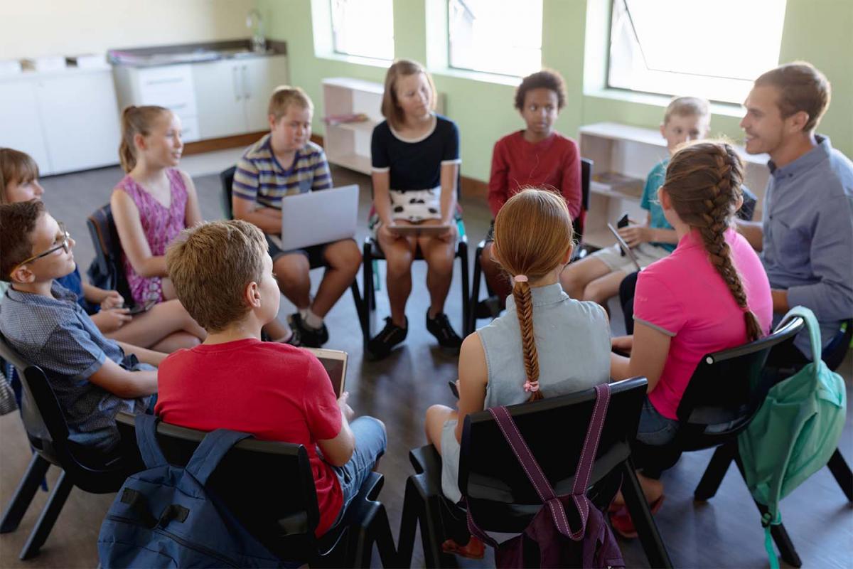 Profesor haciendo un discurso en grupo con sus alumnos