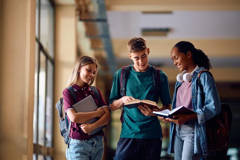 Alumnos de secundaria compartiendo lecturas de un libro de forma alegre